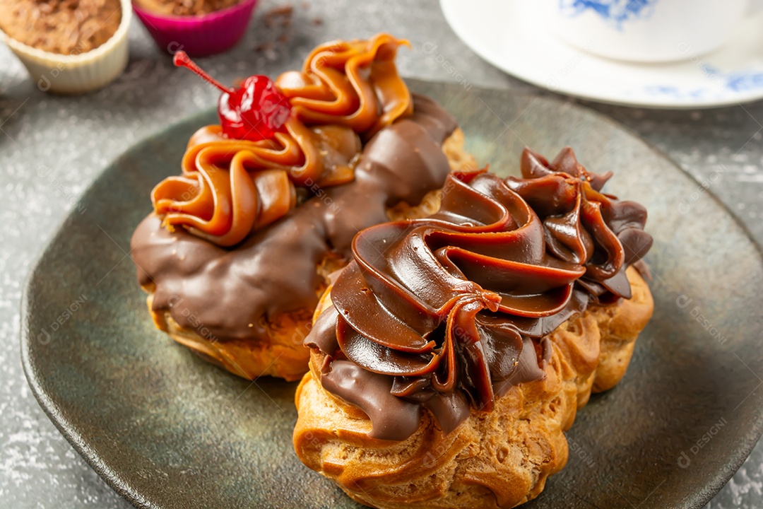 Bomba de chocolate ou éclair é uma padaria brasileira, sobremesa de comida doce, sobre mesa de mármore