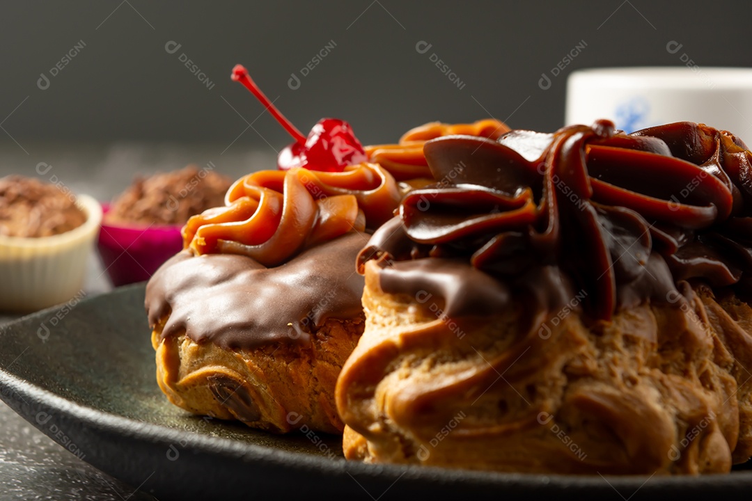 Bomba de chocolate ou éclair é uma padaria brasileira, sobremesa de comida doce, sobre mesa de mármore