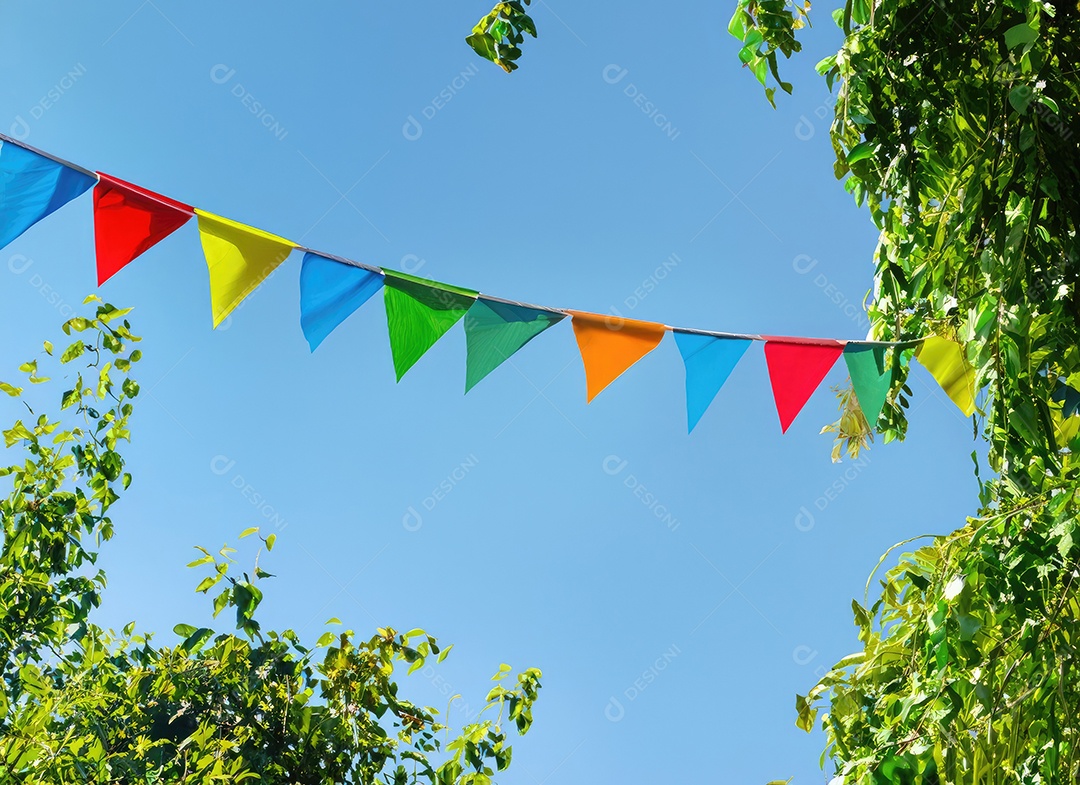 Decoração de corda de flâmula colorida em folhagem de árvore verde no céu azul, fundo de festa de verão.
