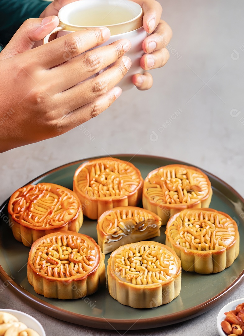 Mãos de pessoas comendo saborosos bolos redondos de lua no festival do meio do outono