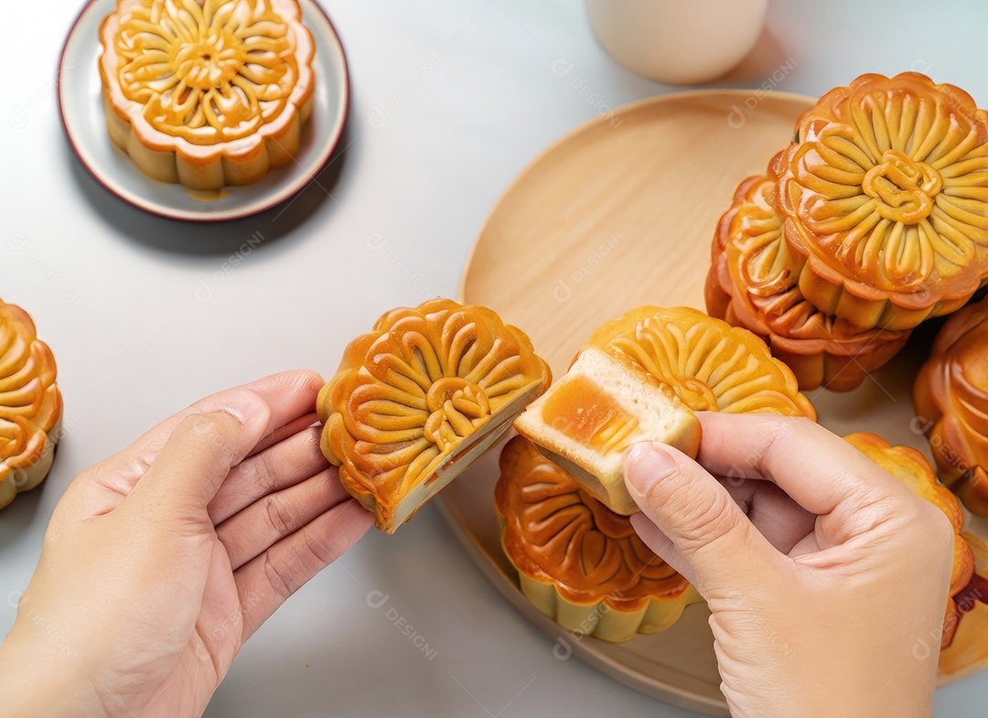 Mãos de pessoas comendo saborosos bolos redondos de lua no festival do meio do outono