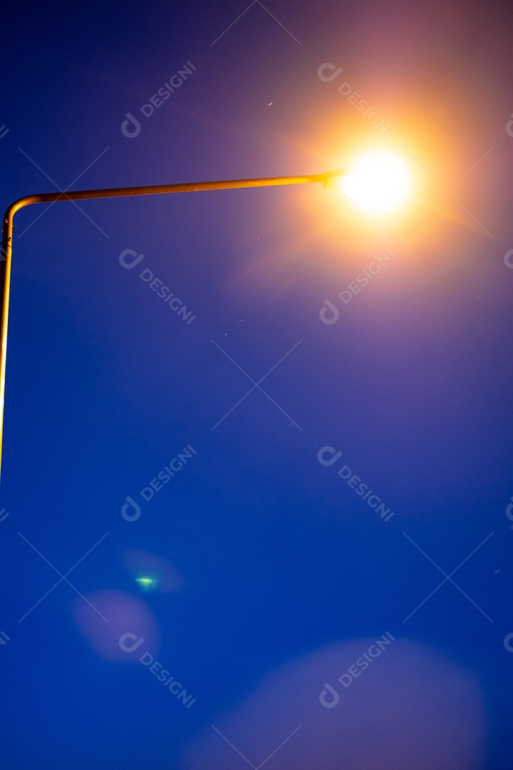 Vista noturna de um poste com luz