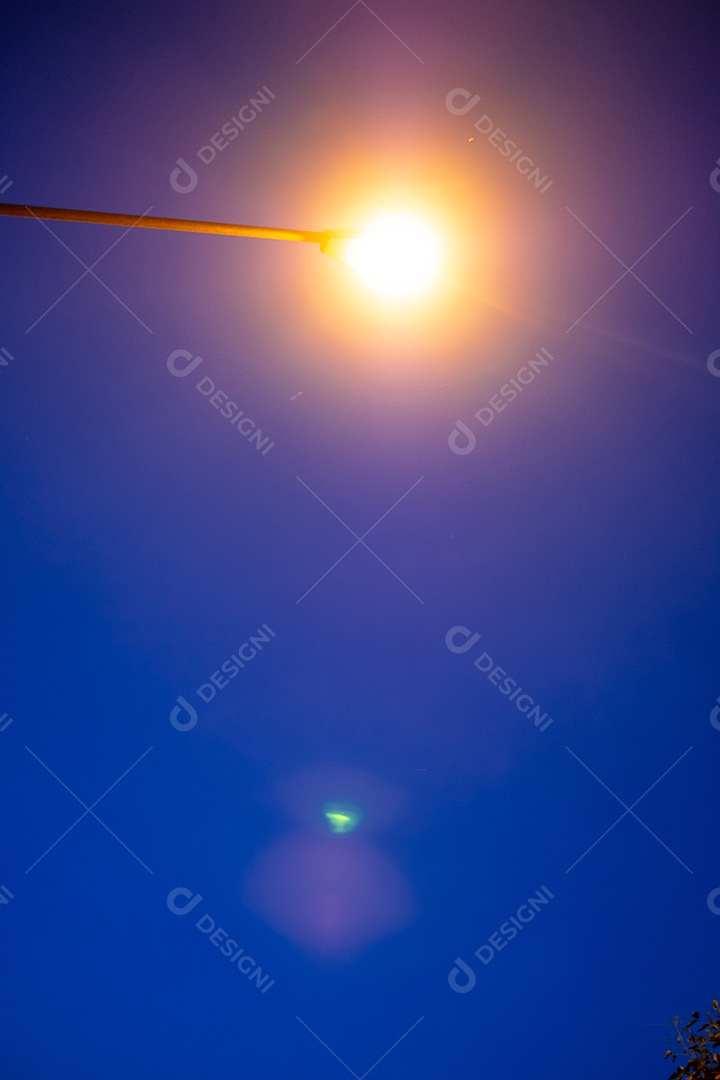 Vista noturna de um poste com luz