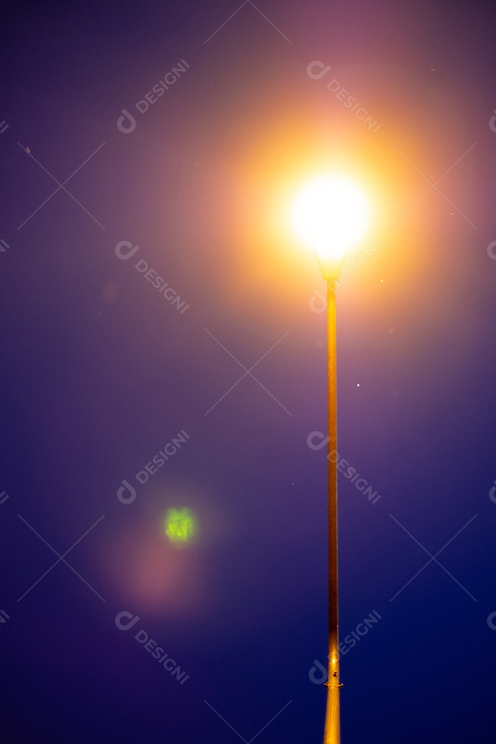 Vista noturna de um poste com luz