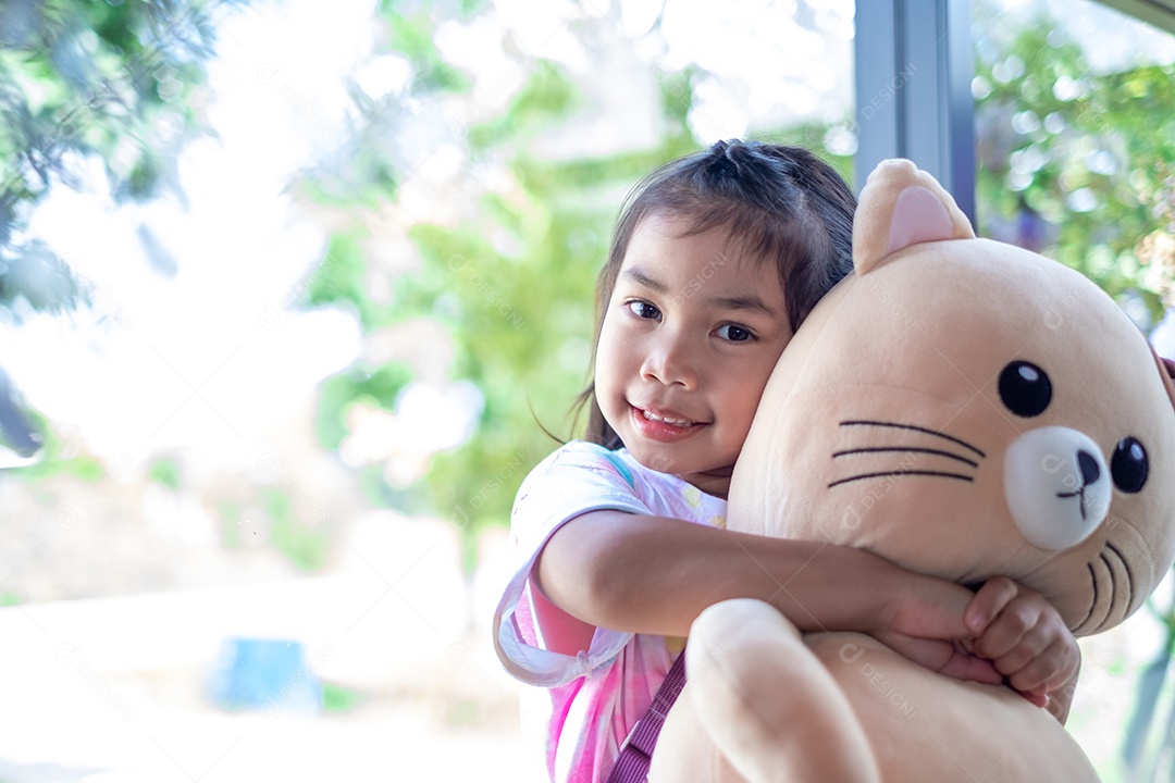 Linda garotinha abraçada com urso de pelúcia