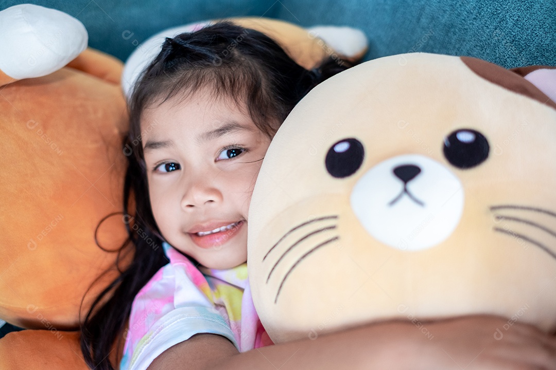 Linda garotinha abraçada com urso de pelúcia