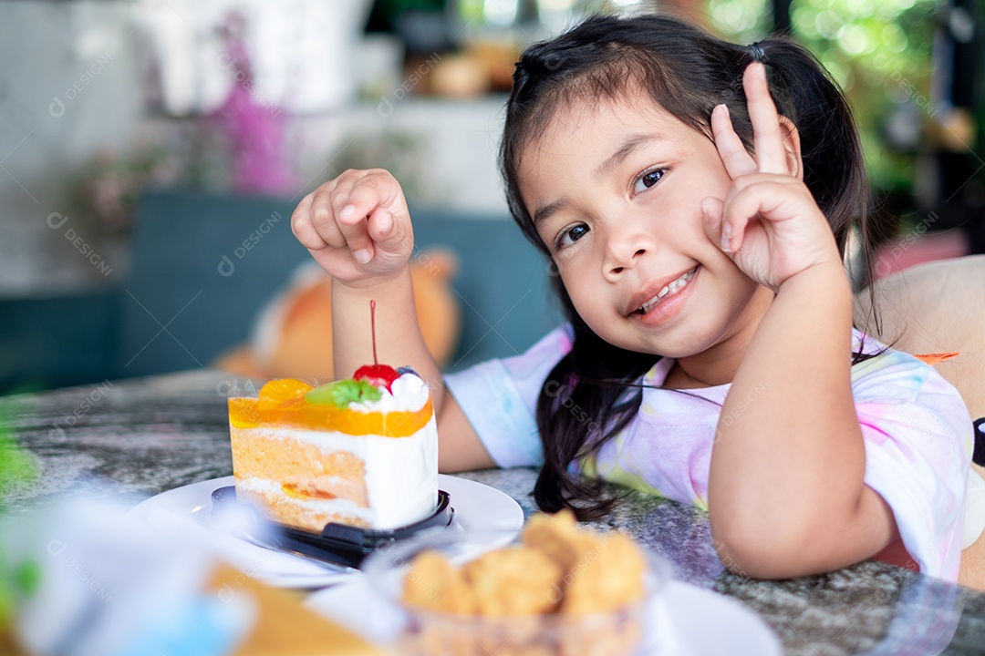 Linda garotinha comendo fatia de bolo
