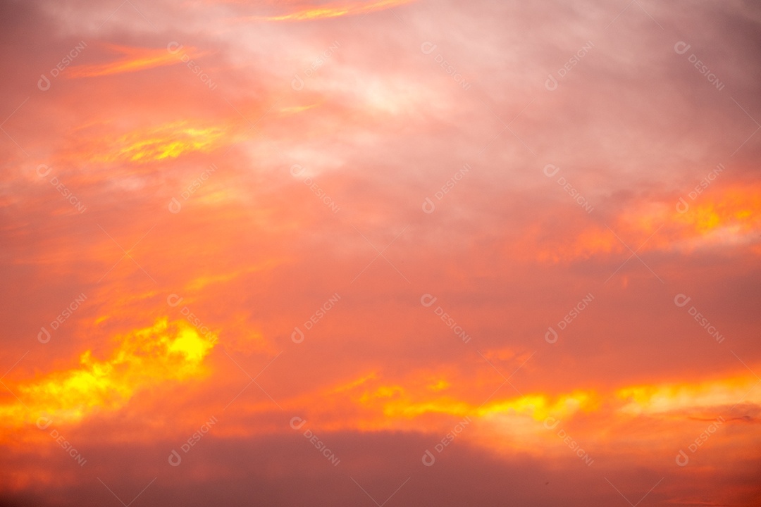 Lindas nuvens laranja gradientes e luz solar no céu azul perfeitas para o fundo