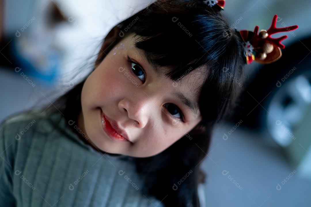 Linda garotinha com tiara de rena de natal