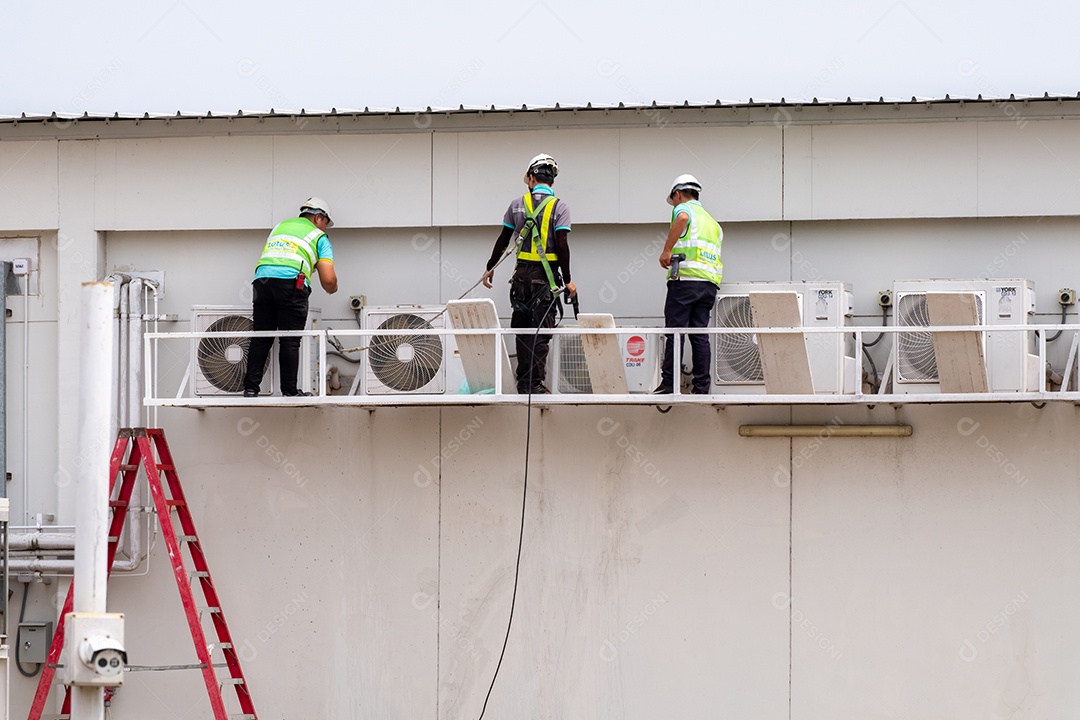 Homens eletricistas instalando ar condicionado