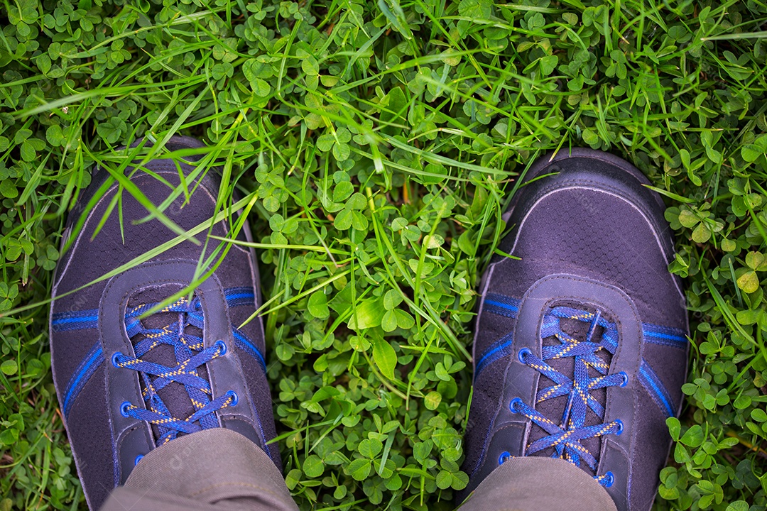 Pernas em sapatos ao ar livre no campo de grama