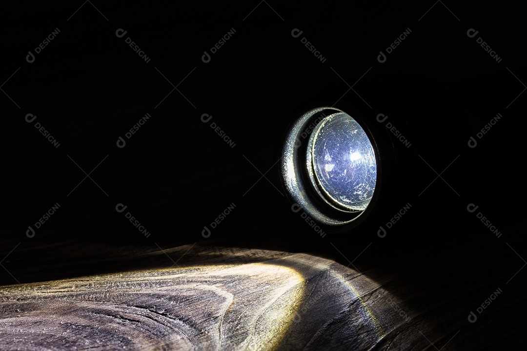 Lanterna operacional led preta na superfície de madeira áspera Atividade secreta noturna ou histórico de pesquisa.