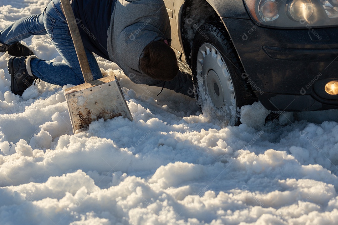 Homem que trabalha no carro preso na neve