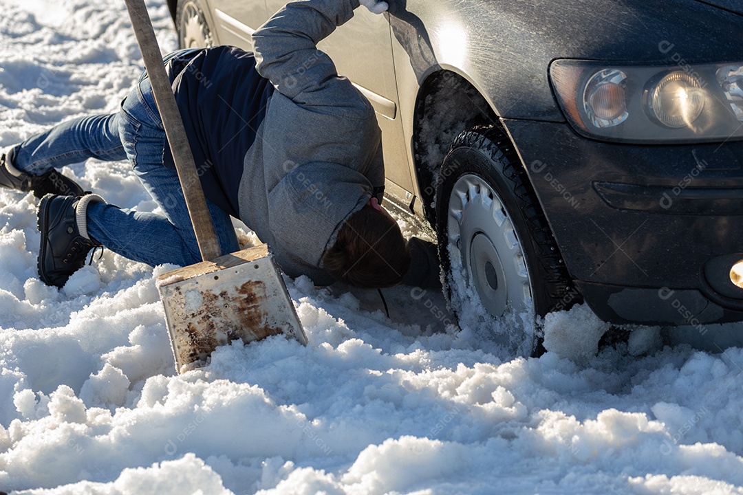 Homem que trabalha no carro preso na neve