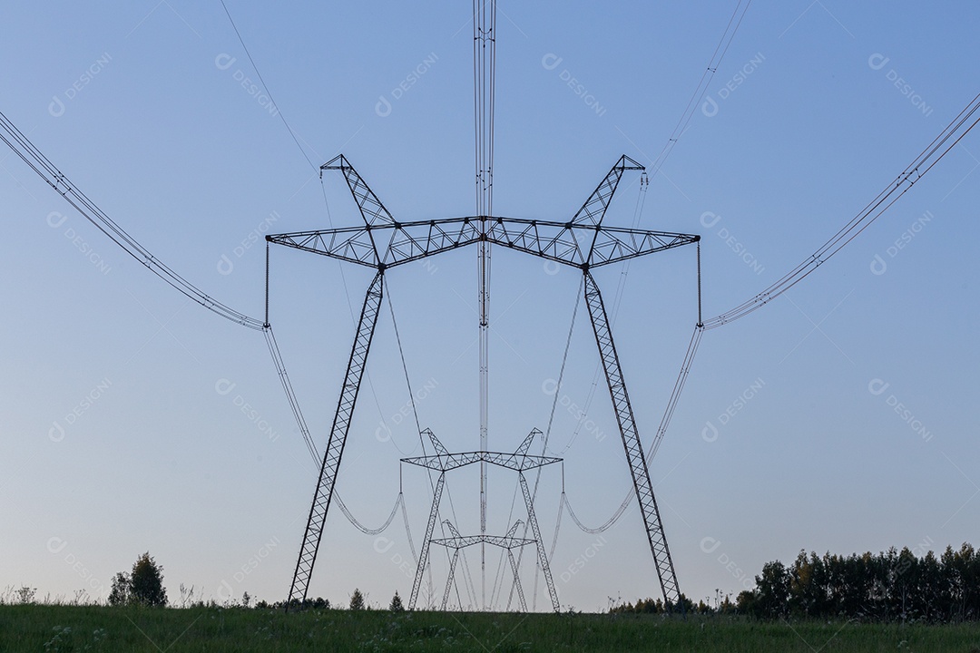 Enormes torres de energia elétrica em campo em dia de verão