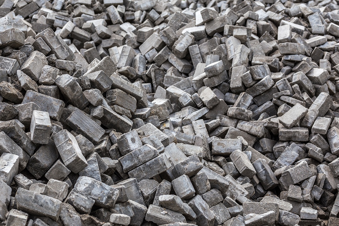 Pilha de tijolos de pavimento cinza desmontados com foco seletivo