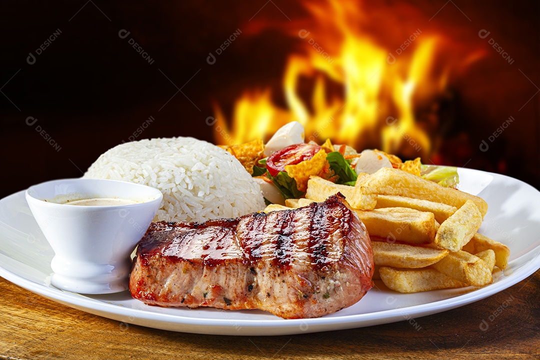 Carne de porco grelhada arroz batata frita e salada
