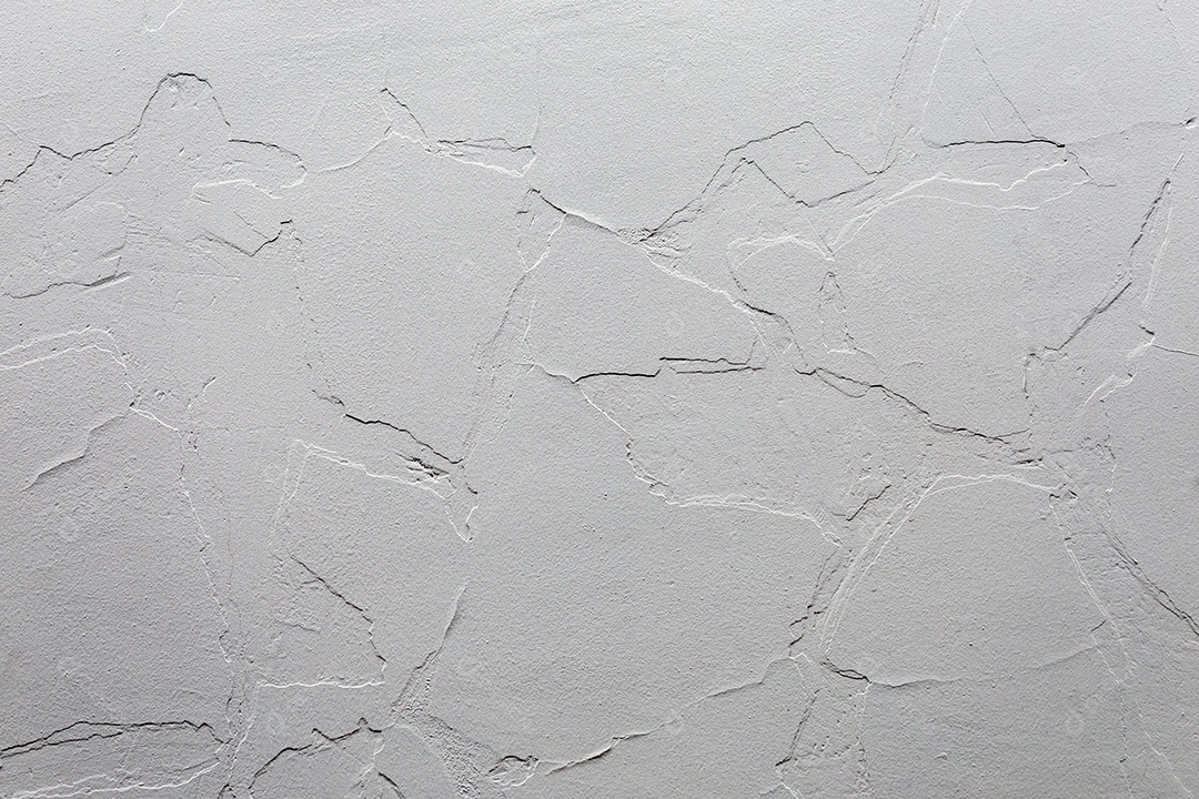 Uma parede de gesso com uma camada antiga rachada sob uma nova