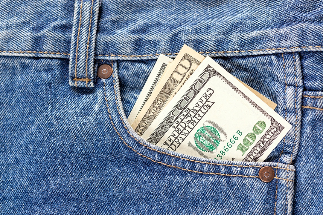 Notas de dólar americano no bolso da calça jeans