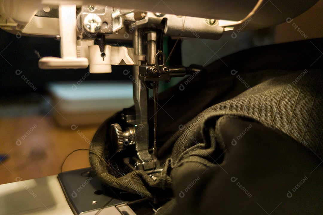 Uma costura gomética escura com máquina e tecido militar verde
