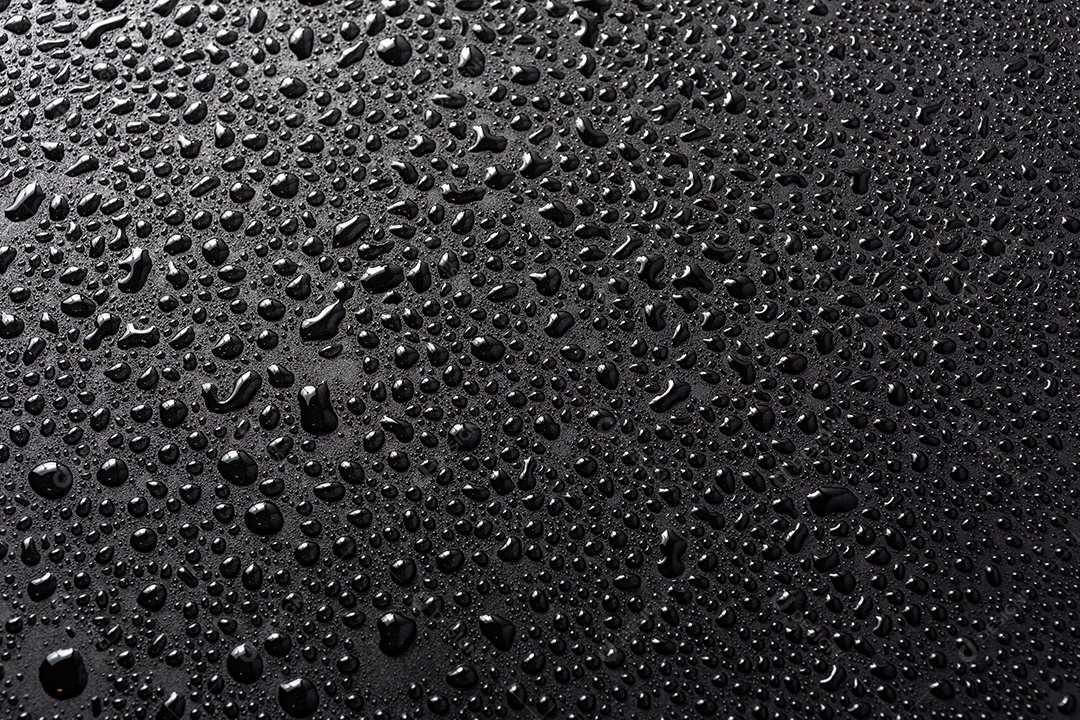 Visão de perto de gotas de água em uma superfície hidrofóbica preta macro sith cuscuz seletivo e fundo desfocado