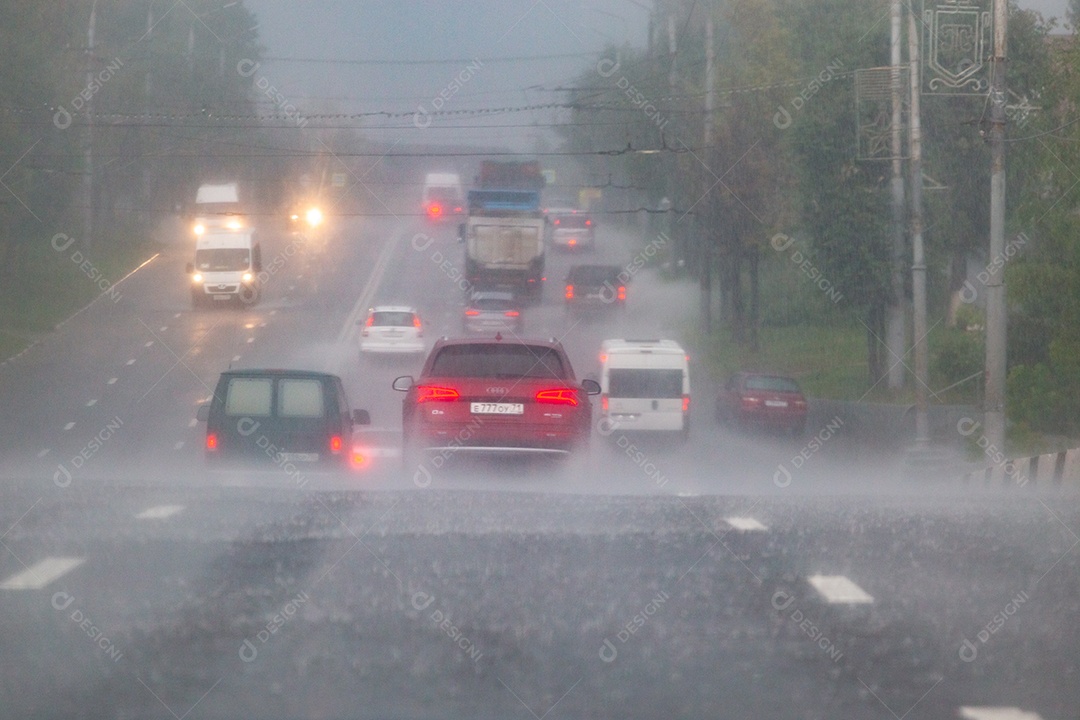 Carros se movendo na estrada de asfalto durante forte chuva de tempestade de verão vista de trás