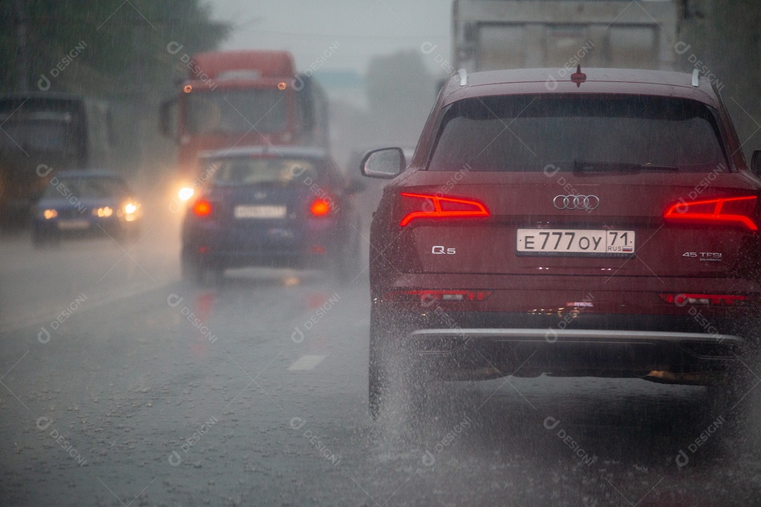 Carros se movendo na estrada de asfalto durante forte chuva de tempestade de verão vista de trás
