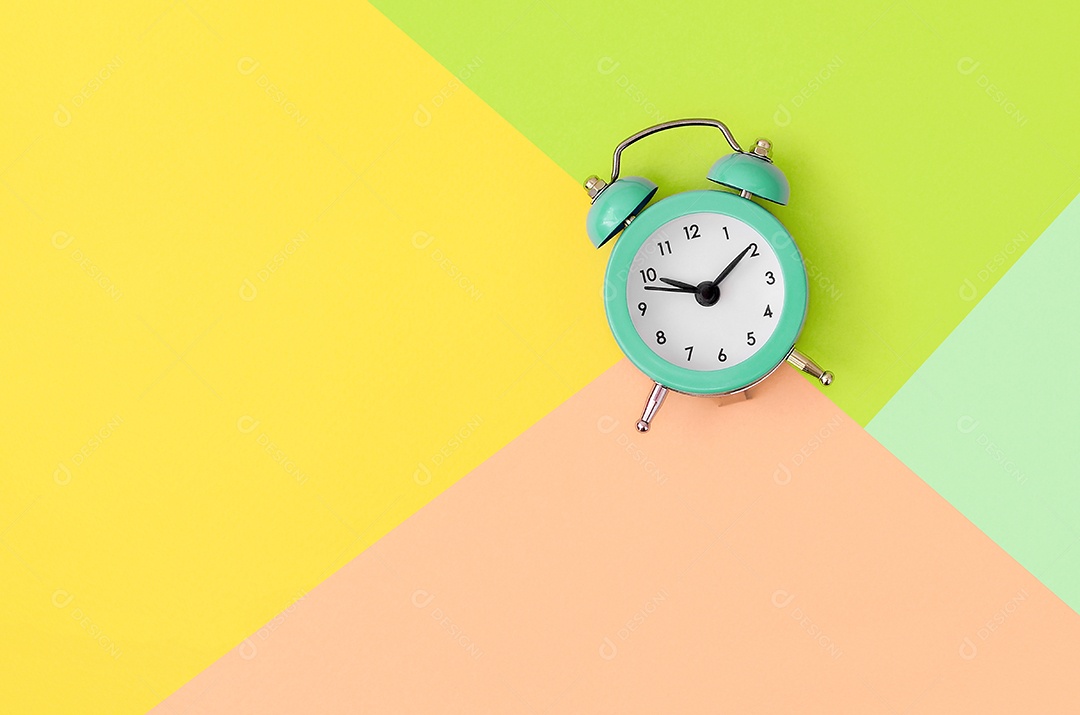 Pequeno despertador turquesa entre áreas coloridas