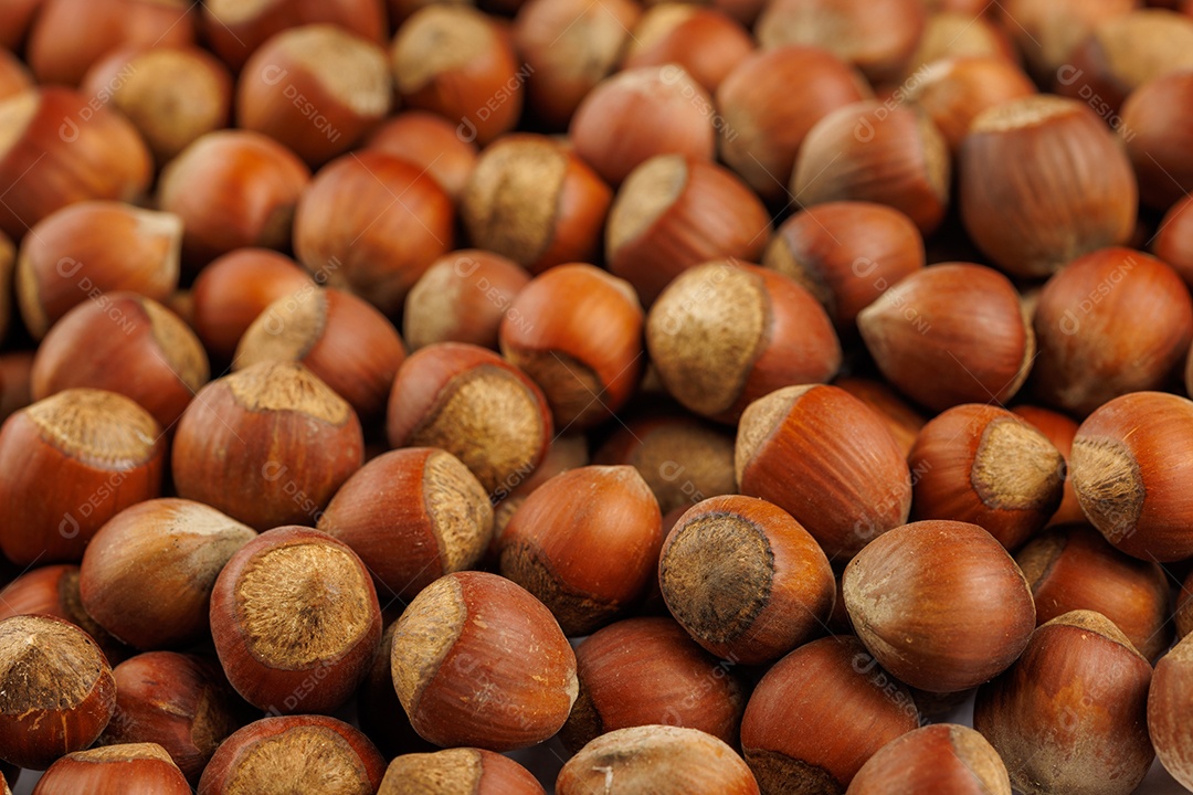 Avelãs com cascas dispostas sobre uma superfície de mesa de madeira marrom