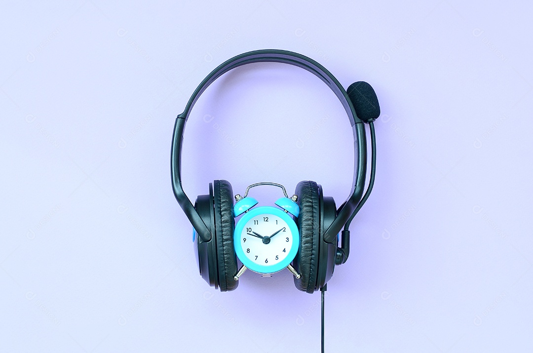 Despertador retrô com fones de ouvido pretos sobre fundo violeta