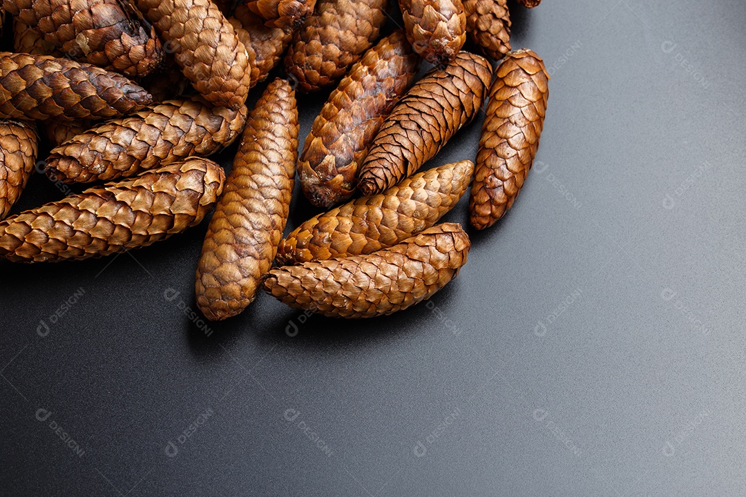 Pilha de pinhas em fundo de plástico preto