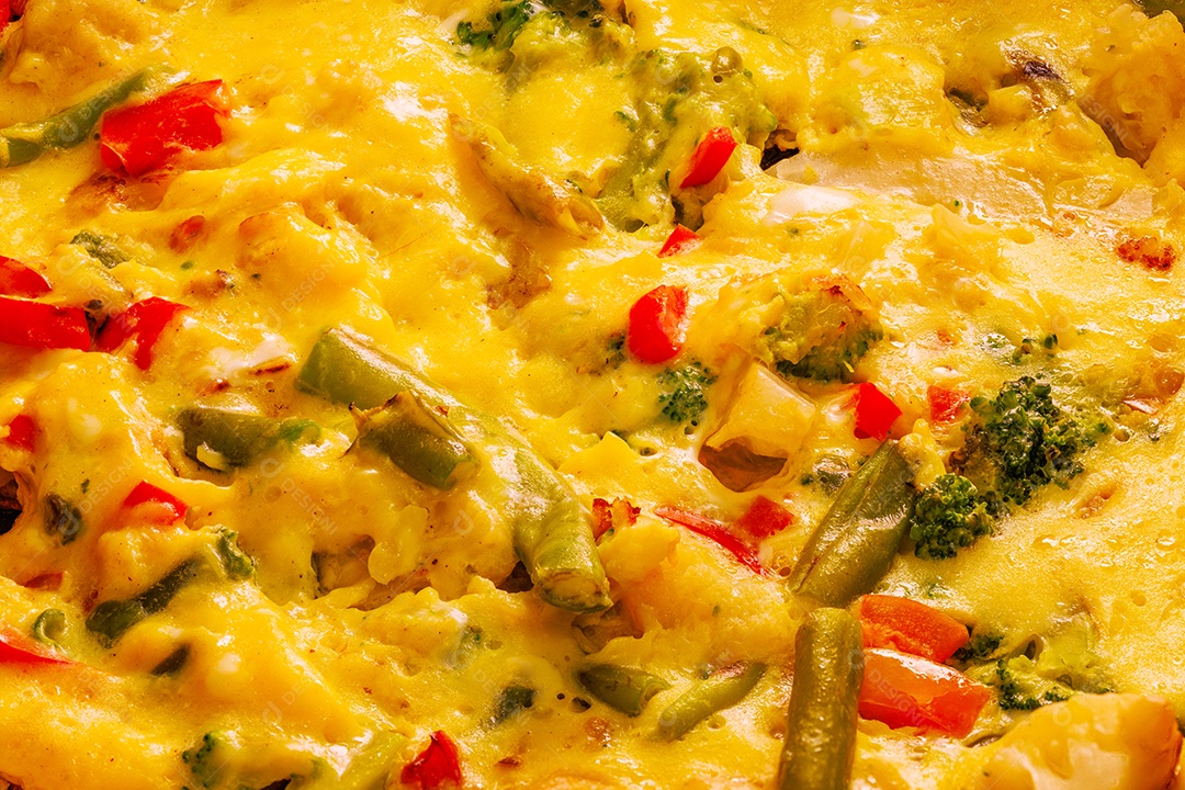 Prato com fatias de omelete de ovos mexidos com legumes e espátula de aço inoxidável