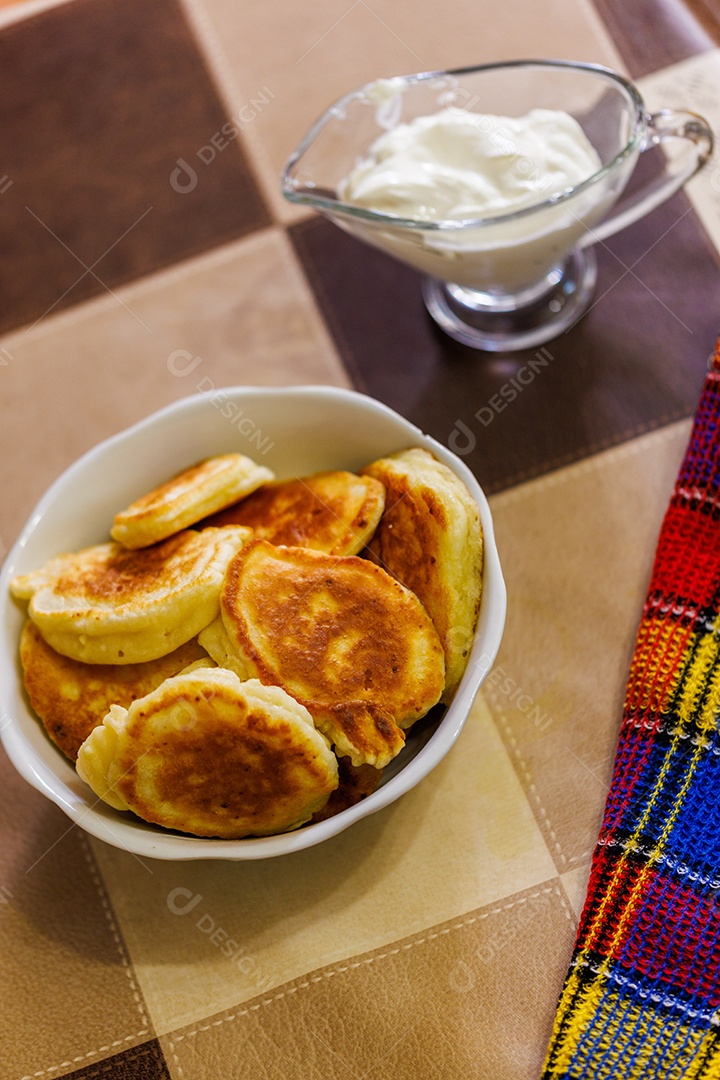 Panquecas russas caseiras em uma tigela de cerâmica na mesa de jantar