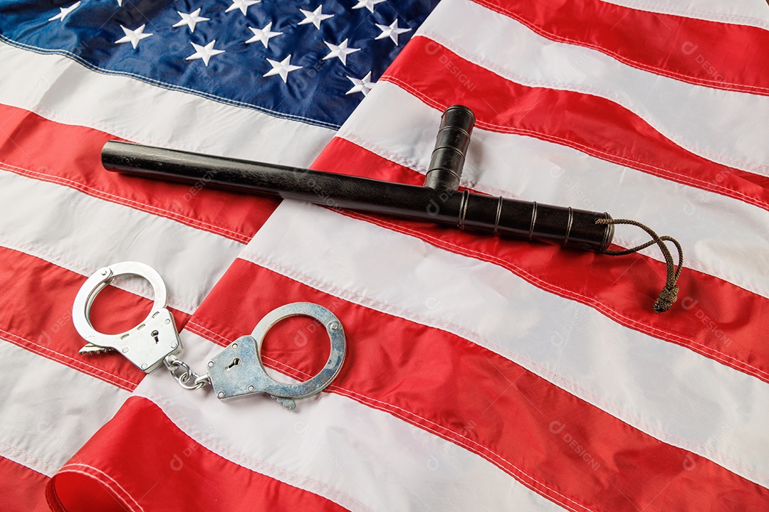 Algemas de metal prateado sobre a bandeira dos EUA em superfície plana