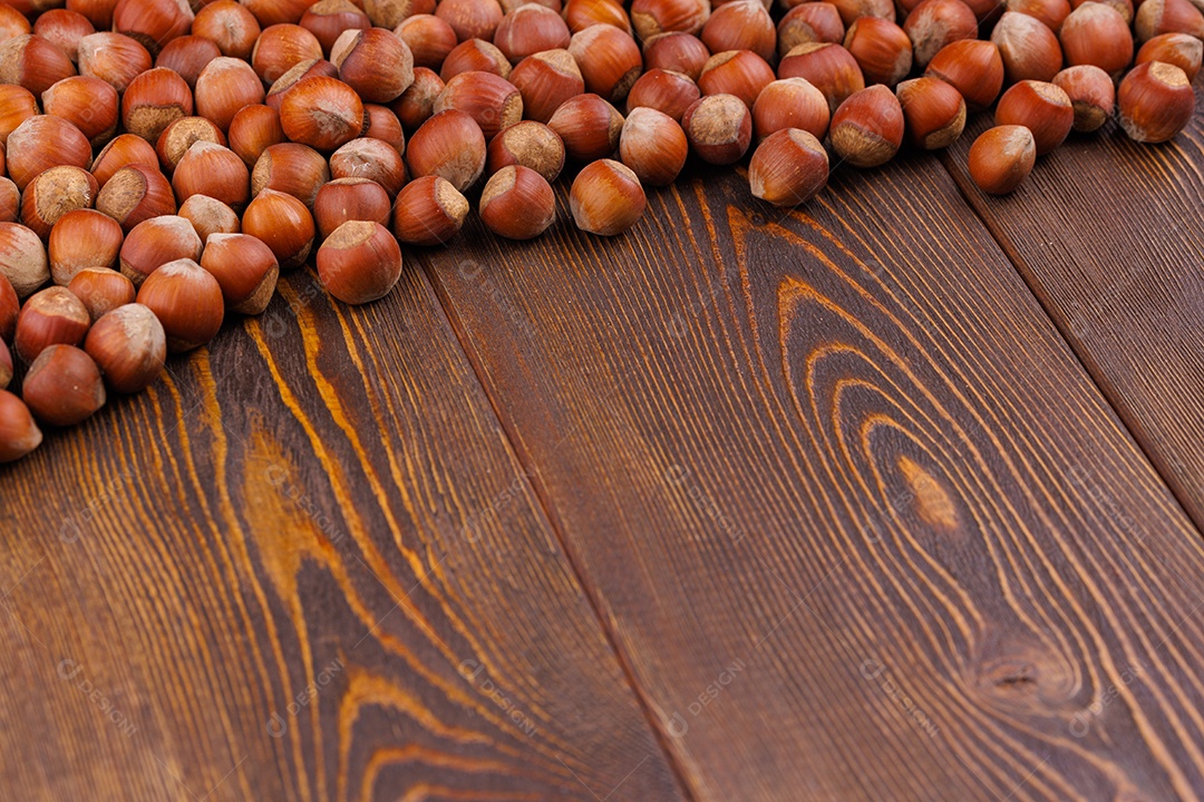 Avelãs com cascas dispostas sobre uma superfície de mesa de madeira marrom