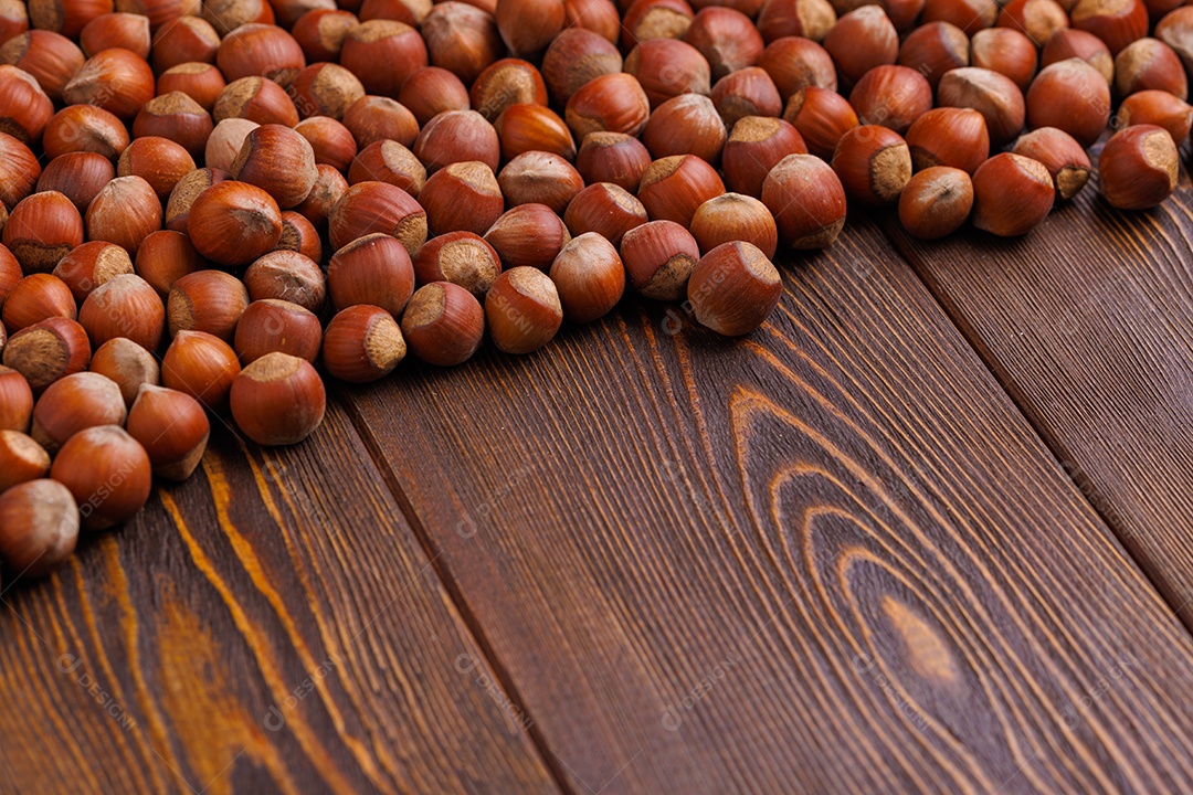 Avelãs com cascas dispostas sobre uma superfície de mesa de madeira marrom