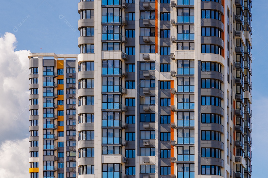 Prédios de apartamentos altos recém-construídos em fundo de céu azul com nuvens brancas