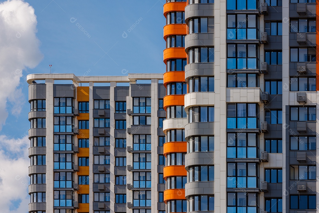 Prédios de apartamentos altos recém-construídos em fundo de céu azul com nuvens brancas
