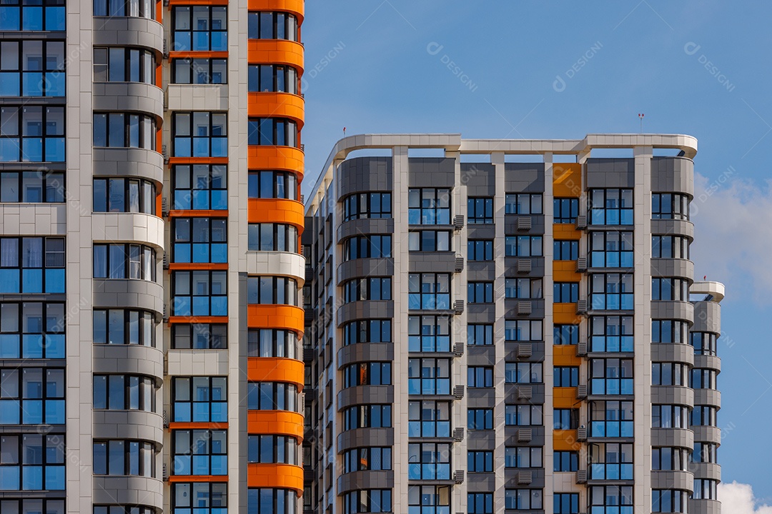 Prédios de apartamentos altos recém-construídos em fundo de céu azul com nuvens brancas