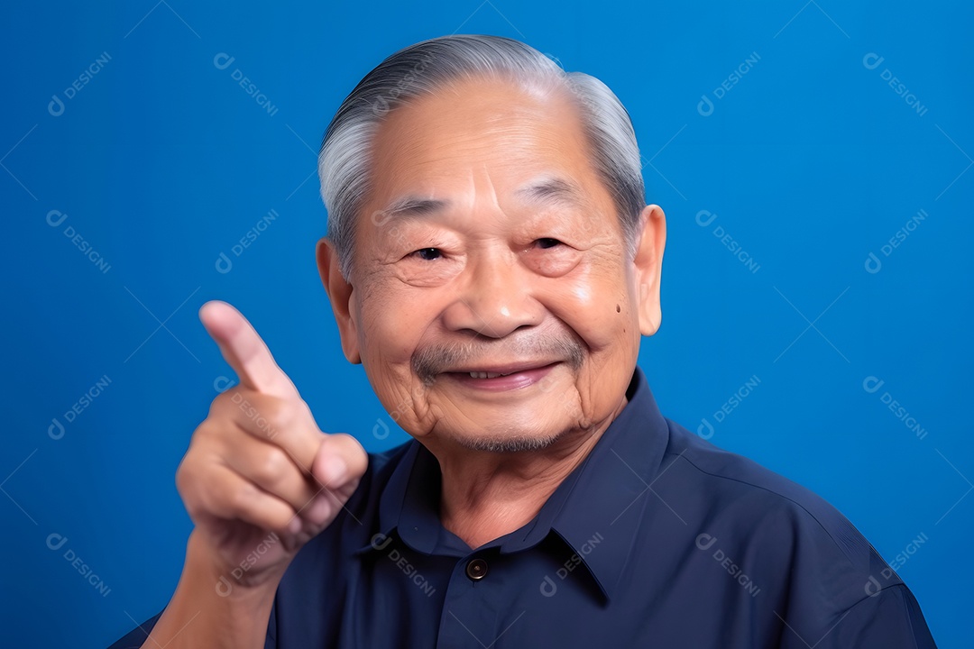 Avô asiático olhando e sorrindo com o dedo indicador erguido sobre fundo azul.