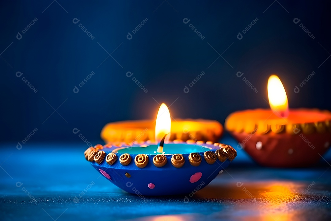 Feliz Diwali - Lâmpadas de argila Diya acesas sobre fundo azul durante a celebração do Diwali.