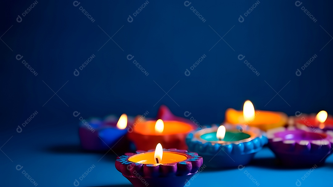 Feliz Diwali - Lâmpadas de argila Diya acesas sobre fundo azul durante a celebração do Diwali.