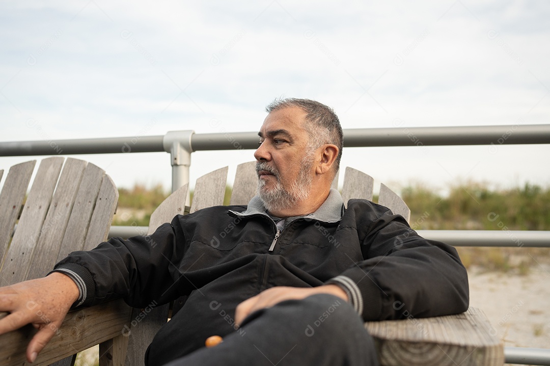 Homem sênior sentado na cadeira de madeira