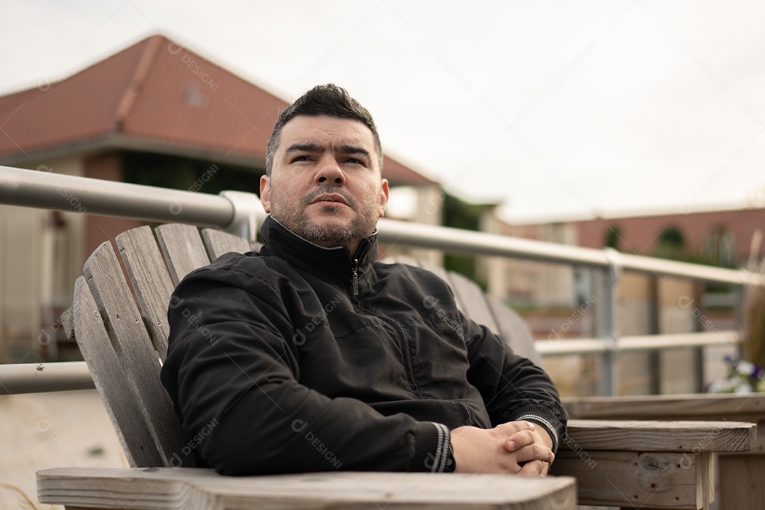 Homem jovem sentado na cadeira de madeira