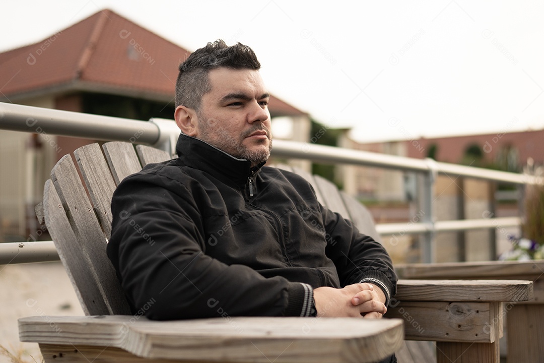 Homem jovem sentado na cadeira de madeira