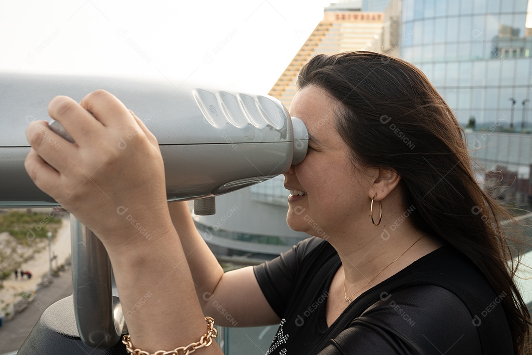 Mulher sorridente olhando pelo telescópio