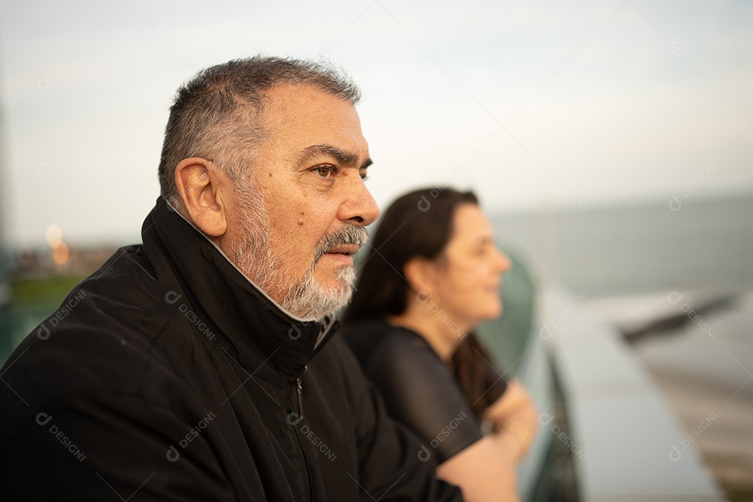 Homem sênior na sacada olhando o mar