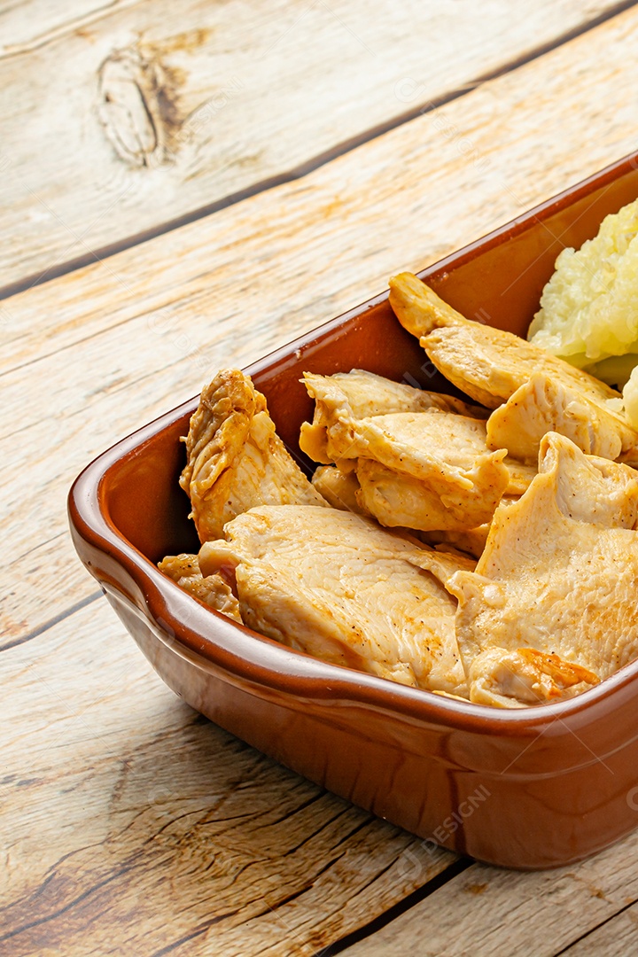 Refeição saudável, frango e couve-flor, em uma tigela sobre a mesa de madeira