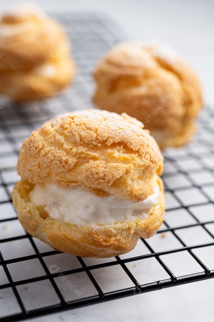 Creme de choux, bolo recheado com chantilly de baunilha sobre grade de metal.