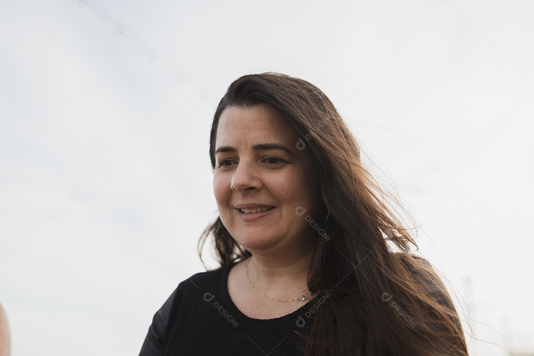 Mulher alegre com cabelos longos sorrindo em retrato de close-up.